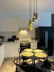 uma cozinha com mesa e cadeiras e uma cozinha com frigorífico em Deluxe Apartment Bochum em Bochum