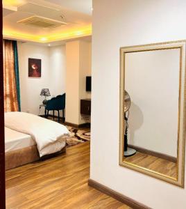 a mirror on a wall next to a bedroom at Gold Crest Luxurious Apartments DHA Lahore by LMY in Lahore