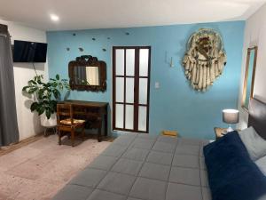 a blue room with a bed and a mirror at Huerta Don Felipe in Irimbo