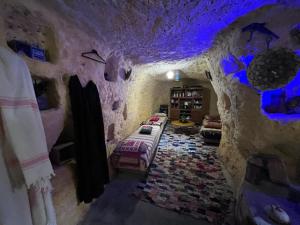 Zimmer in einer Höhle mit lila Lichtern in der Unterkunft Grotte Thami in Bhalil