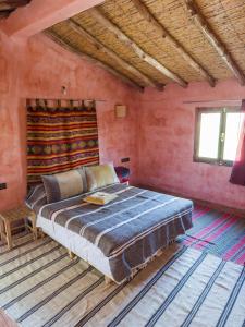 a bedroom with a large bed in a room at Riad Tabhirte in Agdz