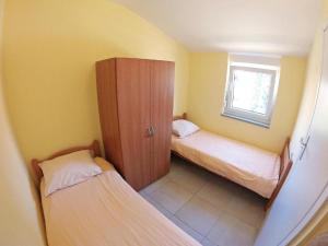 a small room with two beds and a cabinet at SOLARIS ANTONELA Modern Apartments with Sea View & Free Private Parking in Sveti Filip i Jakov +31 photos