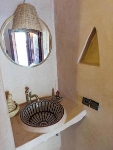 bagno con lavandino e specchio di Riad Tabhirte a Agdz