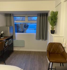 ein Wohnzimmer mit einem Stuhl und einem Fenster in der Unterkunft Private En-suite in Birmingham