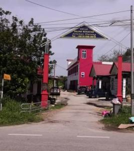 a street with a red building with a sign on it at VILLA HAJAH RUGAYAH BAKRI MUAR in Muar