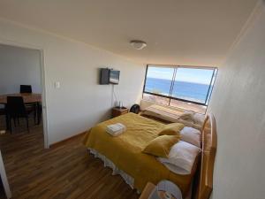 a bedroom with a bed with a view of the ocean at Deptos y habitaciones en sector sur de Iquique, Chile, frente al mar in Iquique