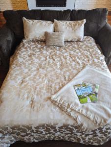 a bed with a blanket and pillows on it at Cherry Street Luxury Apartment in Helena
