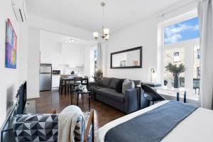 uma sala de estar branca com um sofá e uma cozinha em Liv MTL MTL em Montreal