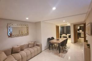 a living room with a couch and a table with chairs at Appart familial chic & confort in Kenitra
