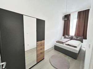 una piccola camera da letto con un letto e un grande specchio di Charming Apartment a Vienna