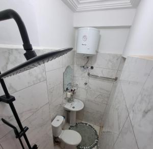 Baño blanco con aseo y lavamanos en 2 bedrooms Apartment, Hillview of Accra, en Kwabenyan