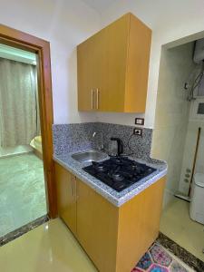 a kitchen with a sink and a stove at Masa Hotel in Mansoura