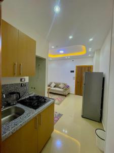 a kitchen with a sink and a refrigerator at Masa Hotel in Mansoura