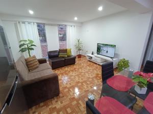 ein Wohnzimmer mit Sofas und einem Flachbild-TV in der Unterkunft II - Zaguan Aparta Hotel Cusco in Cusco