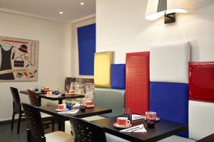 a dining room with two tables and chairs at Hotel Miramar in Paris