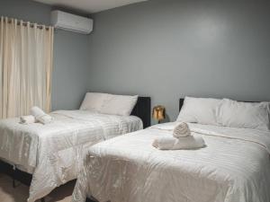 2 letti posti uno accanto all'altro in una camera da letto di Welcome to Villa D’Mirella! a Santiago de los Caballeros