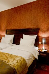 a bedroom with a large bed with white pillows at Hotel Columbus in Krakow