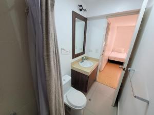 y baño con aseo, lavabo y espejo. en Espacio Luxury Apartments- Bolivar 02, en Lima