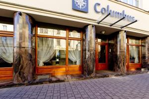 una tienda frente a un edificio con ventanas en Hotel Columbus en Cracovia