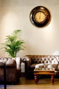 a living room with a couch and a clock on the wall at Hotel Columbus in Kraków