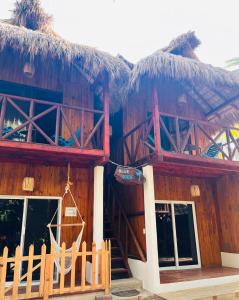 a wooden building with a thatched roof with a porch at Blue House in Puerto Escondido