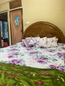 łóżko z kwiatową kołdrą i poduszkami w obiekcie Holiday home in Sylhet (Kasobir) w mieście Kilsby