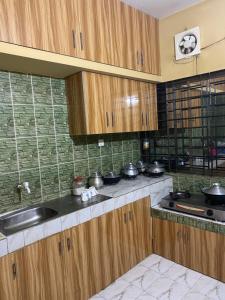 Holiday home in Sylhet (Kasobir) في Kilsby: مطبخ بدولاب خشبي ومغسلة