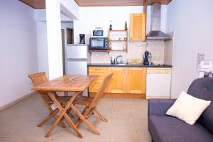 a small kitchen with a wooden table and a couch at JDREAMLOC in Kourou
