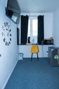 a room with a chair and a clock on the wall at JDREAMLOC in Kourou