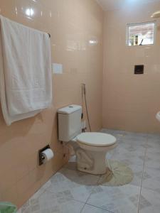 a bathroom with a toilet and a towel on the wall at Casa confortável em Estancia in Estância