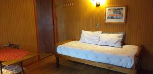 Dormitorio pequeño con cama y mesa en Don Zoilo, en Castro