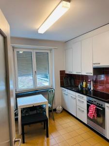 een keuken met witte kasten en een tafel en een tafel sidx sidx sidx bij Apt near Basel Centre and Airport in Bazel