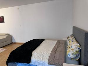 een slaapkamer met een bed met een zwarte deken erop bij Apt near Basel Centre and Airport in Bazel