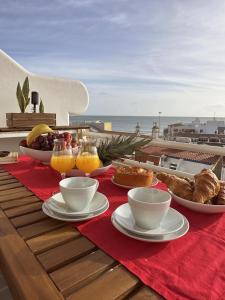 Deluxe Flat by Albufeira Holidays في ألبوفيرا: طاولة مع الطعام والمشروبات على طاولة مع المحيط