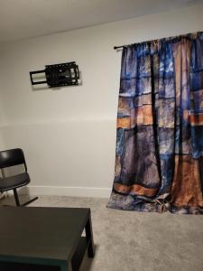 a curtain in a room with a table and a chair at Private Family Hideaway or Business Travel in Edmonton - 2 Bedroom Apartment in Edmonton