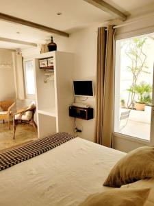 a bedroom with a bed and a window at La maison blanche Intra-Muros Free parking in Aigues-Mortes