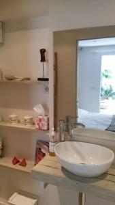 a bathroom with a white sink and a mirror at La maison blanche Intra-Muros Free parking in Aigues-Mortes