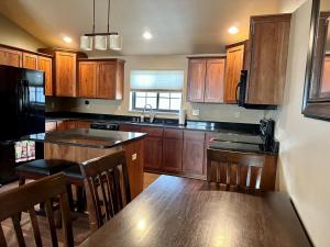 a kitchen with wooden cabinets and a kitchen table with a counter at Sweet Pea in Red Lodge