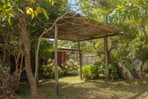 una pérgola de madera en un patio con árboles en La Fuga, en La Pedrera