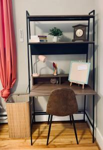 a desk with a chair and a clock on a shelf at Comfy Studio #3, Central Location, Parking in Halifax