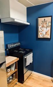 a kitchen with a stove and a blue wall at Comfy Studio #3, Central Location, Parking in Halifax