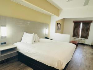 un grande letto bianco in una camera d'albergo di America's Best Inns Flowood a Flowood