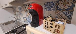 a red appliance sitting on top of a kitchen counter at La Casa sulla Piazza in Sciacca