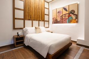 1 dormitorio con 1 cama y una pintura en la pared en Prixma Hotel, en San Andrés