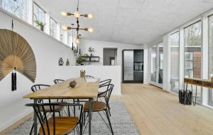 Cozy Home In Aakirkeby With Kitchen في Vester Sømarken: غرفة طعام ومطبخ مع طاولة وكراسي