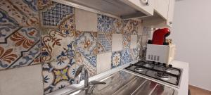 a kitchen with a sink and a stove and tiles at La Casa sulla Piazza in Sciacca +40 photos