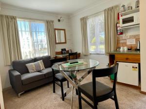 ein Wohnzimmer mit einem Glastisch und einem Sofa in der Unterkunft Swansea Cottages & Lodge Suites in Swansea