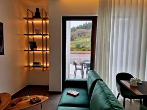 a living room with a green couch and a table at 3M Hostel & Suites in Alvaiázere