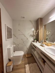 Deluxe Flat by Albufeira Holidays في ألبوفيرا: حمام مع مرحاض ومغسلة ومرآة