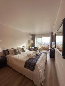 Deluxe Flat by Albufeira Holidays في ألبوفيرا: غرفة نوم بسرير كبير ونافذة كبيرة